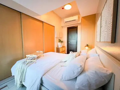 a large bed with white pillows in a room at Prime Uptown BGC | Stylish 1BR Getaway #upt1 35j in Manila