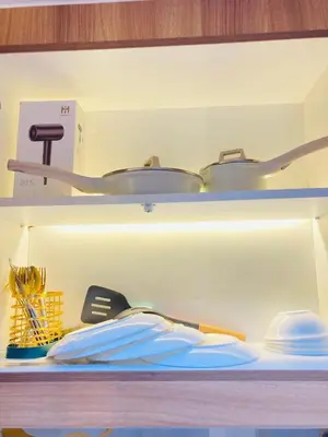 a shelf with some pots and pans on it at Casa Cion Staycation in Manila