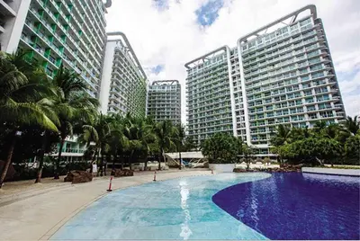 a large swimming pool in front of tall buildings at 1BR Condotel at Azure Urban Resort Near Airport #AZ07 in Manila