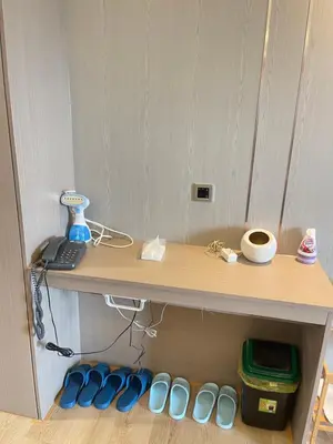 a desk with a keyboard and blue shoes under it at Venice Luxe Stay, Studio Type, King Bed, 65 TV-Netflix 40\u5e73\u65b9\u56db\u4eba\u516c\u5bd3 \u53a8\u5177\u9f50\u5168 in Manila