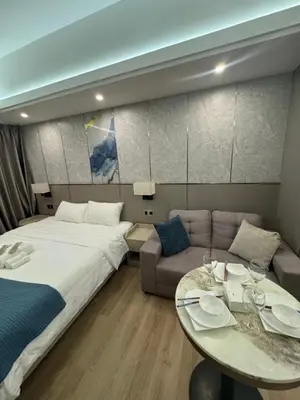 a bedroom with a bed and a table and a couch at Venice Luxe Stay, Studio Type, King Bed, 65 TV-Netflix 40\u5e73\u65b9\u56db\u4eba\u516c\u5bd3 \u53a8\u5177\u9f50\u5168 in Manila