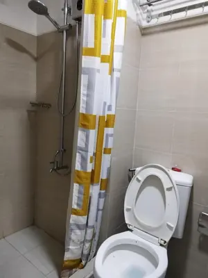 a bathroom with a toilet and a shower curtain at Avocado Room near MOA PICC 2 BEDS in Manila