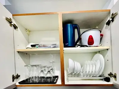 a cupboard with dishes and utensils in it at Condo in Ermita near UP-PGH, St Lukes & US Embassy in Manila