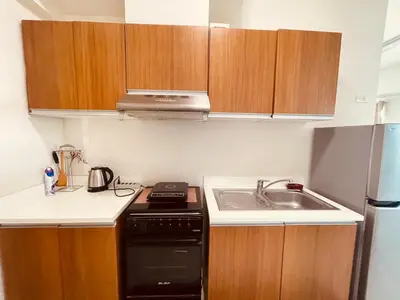 a small kitchen with a stove and a sink at Condo in Ermita near UP-PGH, St Lukes & US Embassy in Manila