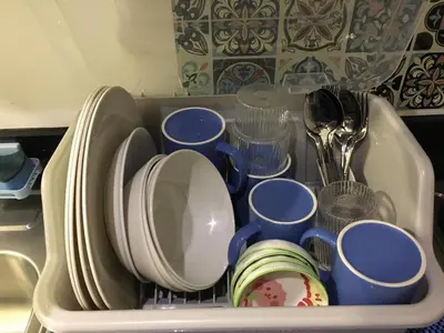 a dish rack filled with plates and cups at KakaI's Staycation in Fame in Manila