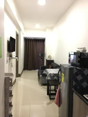 a living room with a couch and a tv in a room at KakaI's Staycation in Fame in Manila