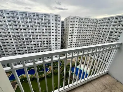 a balcony with two large buildings in the background at Shore residences A 1br Near SM MOA in Manila