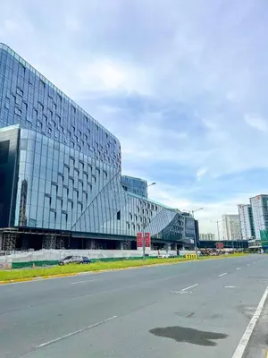 a large glass building with a road in front of it at Modern & Luxury 2BR near Solaire, Okada, Airport in Manila