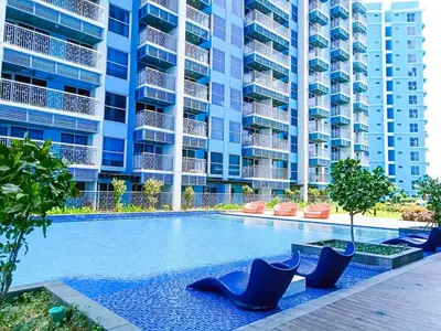 a swimming pool in front of a large apartment building at Modern & Cozy 2BR near Okada, Solaire, Airport in Manila