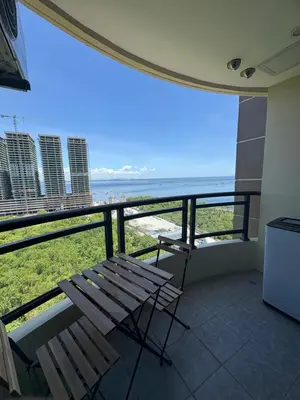 a balcony with a chair and a view of the ocean at Sybaysuites staycation near Okada COD MOA NAIA airport Solaire MSV1808H in Manila