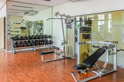 a gym with several treadmills and a row of machines at Cozy Studio in Salcedo Village Makati in Manila
