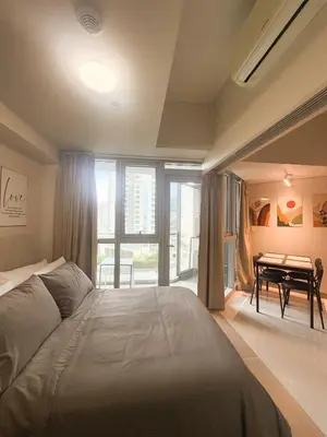 a bedroom with a bed and a table and a dining room at City View Stay in Uptown BGC in Manila