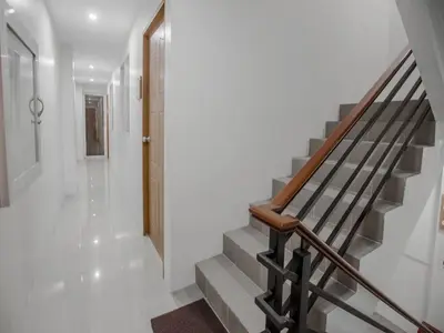 a staircase in a home with white walls and a stair case at The Quarters in Manila