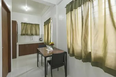 a dining room with a table and a kitchen at OYO 736 Jade Apartelle in Cabuyao