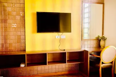 a living room with a television on a yellow wall at Capital O 897 Takara Hotel And Events Place in Calamba