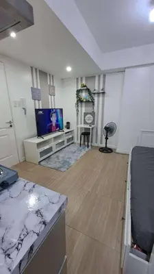 a living room with a flat screen tv and a kitchen at AZURE BICUTAN MAUI G14 TOWER POOL View in Manila