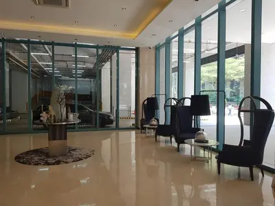 a lobby with chairs and tables in a building at 1BR condo at One Uptown Residence in BGC in Manila