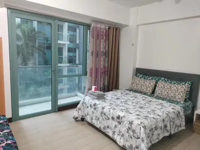 a bedroom with a bed and a large window at Pasay Condotel Near Airports in Manila
