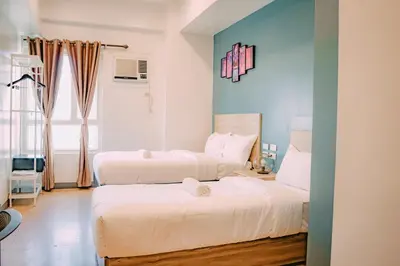 a bedroom with two beds and a window at I Suites Hotel Malate in Malate