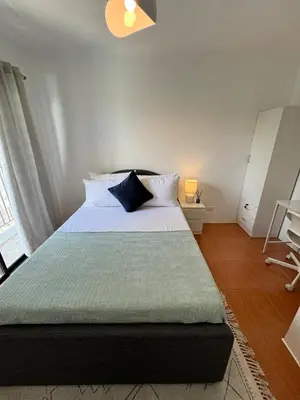 a bedroom with a large bed with white sheets and blue pillows at Modern Minimalist Luxe Retreat 2 Bedroom with parking in Manila