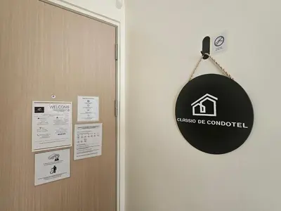 a sign hanging on a wall next to a door at Entire Studio Unit Classio De Condotel at Urban Deca Cubao in Manila