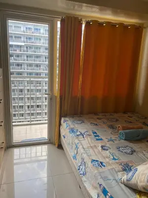 a bedroom with a bed and a large window at Sebby's staycation at Shell MOA in Manila