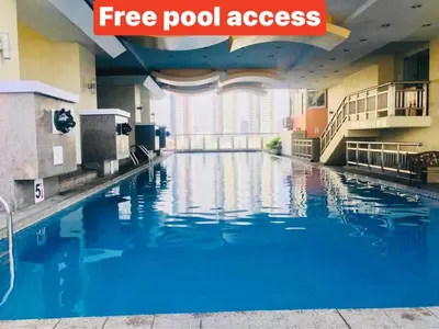a pool in a hotel room with blue water at Birch Tower A8 Front of Robinson Mla BayFree Pool in Manila