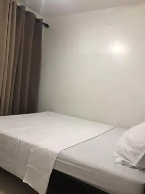 a small bedroom with a bed with white sheets at Birch Tower A8 Front of Robinson Mla BayFree Pool in Manila