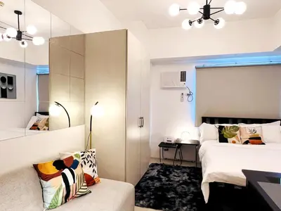 a bedroom with a bed and a couch and a mirror at 1BR Condotel with Balcony at SM Light Residences #LT01-1 in Manila
