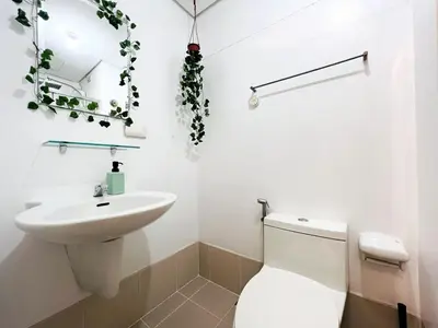 a white bathroom with a toilet and a sink at 1BR Condotel with Balcony at SM Light Residences #LT01-1 in Manila