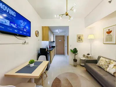 a living room with a couch and a tv on the wall at 1BR Condotel with Balcony at SM Light Residences #LT03-1 in Manila