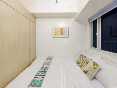 a small bedroom with a bed and a window at 1BR Condotel with Balcony at SM Light Residences #LT03-1 in Manila
