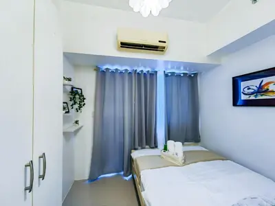 a small room with two beds and a window at 1BR Condotel with Balcony at SM Light Residences #LT06-1 in Manila