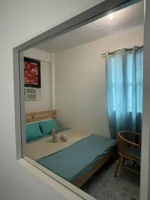 a reflection of a bedroom with a bed in a mirror at D and A Transient Inn Taguig in Taguig