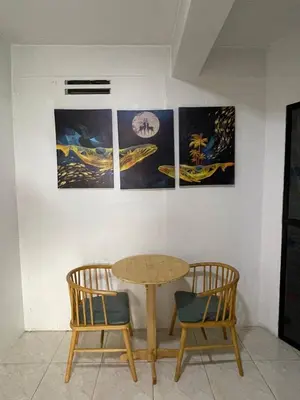 a table and two chairs in a room with pictures at D and A Transient Inn Taguig in Taguig