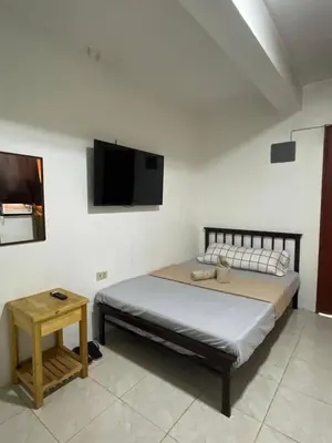a bedroom with a bed and a tv on the wall at D and A Transient Inn Taguig in Taguig