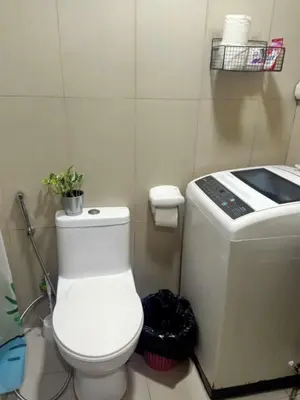 a bathroom with a white toilet and a counter at La Maison Breeze Residence in Manila
