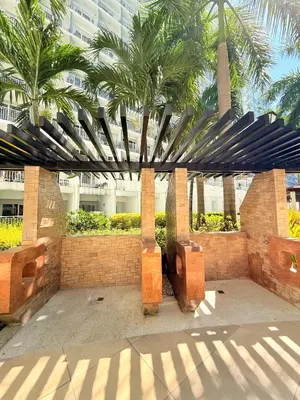 a building with palm trees in front of a building at Shell Residences MOA Prime - Paul in Manila