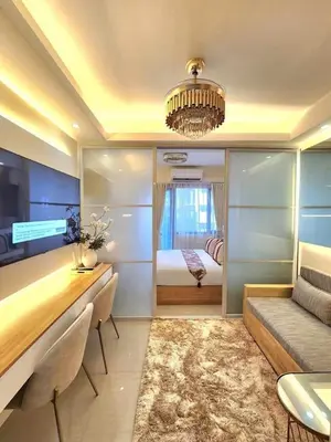 a room with a couch and a bed and a table at Exquisite space in Manila