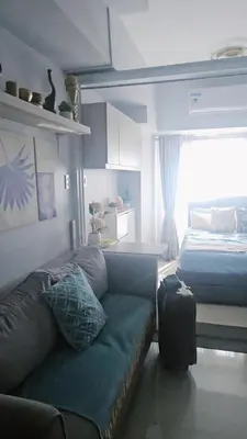 a living room with a couch and a bed at Coast Residences in Manila