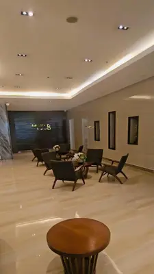 a lobby with chairs and tables in a building at Coast Residences in Manila