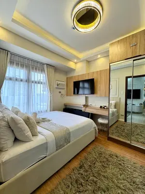 a large bedroom with a large bed and a desk at Manila Bay Suite near PICC in Manila