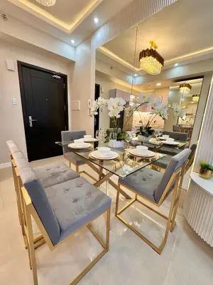 a dining room with a glass table and chairs at Manila Bay Suite near PICC in Manila