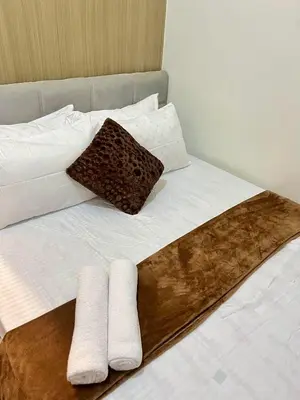 a bed with two pillows and two towels on it at Staycation near in Mall of Asia located in Shore1 and 2 Residences in Manila