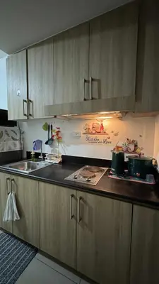 a kitchen with wooden cabinets and a sink at Staycation near in Mall of Asia located in Shore1 and 2 Residences in Manila