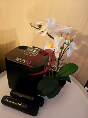 a table with a phone and flowers on it at Mall of Asia Sea Residences- Milan Staycations Casa Juan in Manila