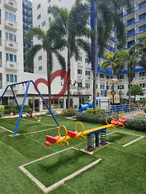 a playground in a park in front of a building at Mall of Asia Sea Residences- Milan Staycations Casa Juan in Manila