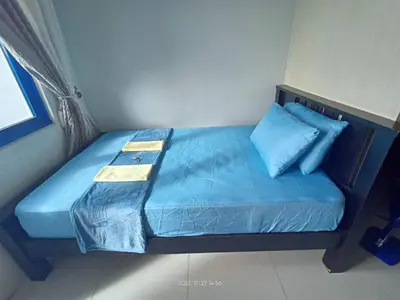 a bed in a room with blue sheets and pillows at Sea Residences Mall of Asia Viann in Manila