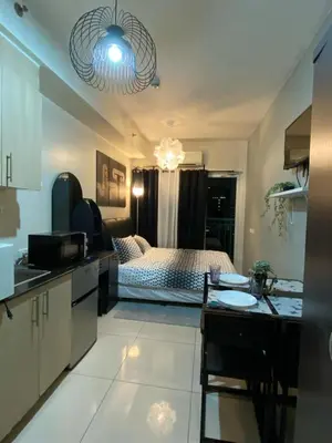 a kitchen and a bedroom with a bed and a table at Cozy Staycation in Pasay in Manila