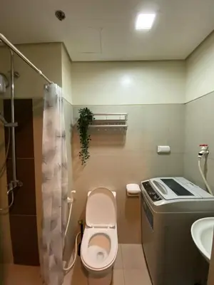 a small bathroom with a toilet and a sink at Cozy Staycation in Pasay in Manila